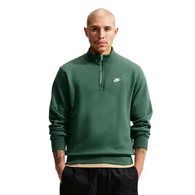 Front view of a model wearing the Fir Green Nike Club fleece with a half-zip collar and white chest logo.
