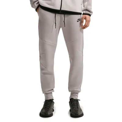 Front view of College Grey Nike Tech Fleece joggers showing the slim tapered fit, drawcord and black logo.
