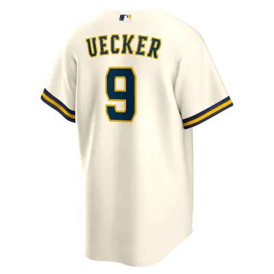 Angled back view of cream Nike Brewers Bob Uecker jersey with his name, navy number 9 and MLB logo at the neck.