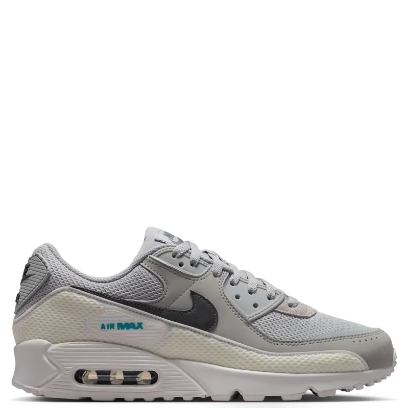Medial side view of the Air Max 90 Premium showing grey overlays, dark Swoosh branding and visible Air cushioning.