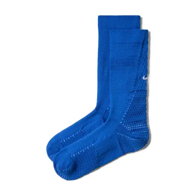 Angled product view of blue Nike Unicorn crew socks with white Swooshes and ventilated cushioning zones.