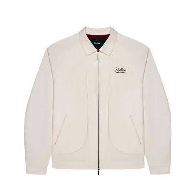 Front view of the ivory Malbon Golf Field jacket showing its zipper, welt pockets and chest embroidery