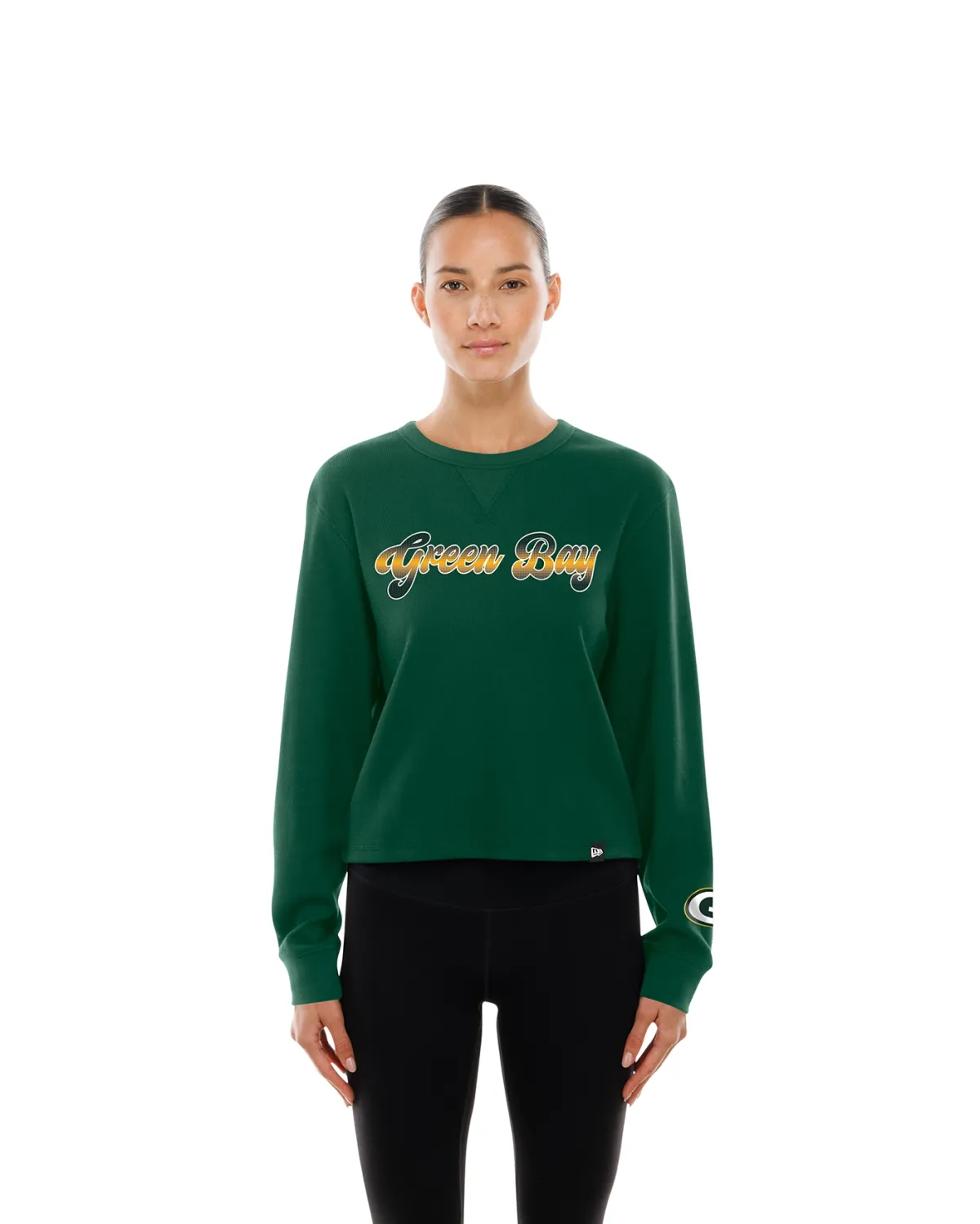 Front view of a model wearing the green New Era Packers cropped thermal top with Green Bay lettering