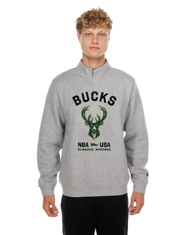 Front view of a model wearing the Heather Grey New Era Bucks Primary 1/4 Zip Sweatshirt with team graphics.