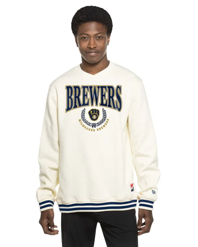 Front view of cream New Era Brewers Crest sweatshirt with embroidered twill graphics and navy-striped cuffs and hem.