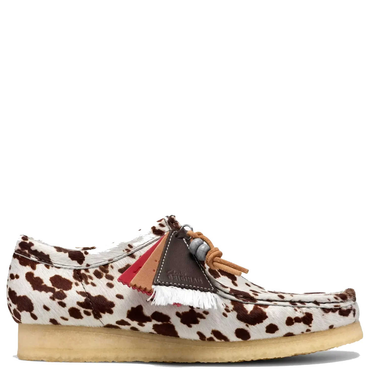Side view of Clarks Wallabee in Brown Cow Print with a hair-on upper, collectible fobs and natural crepe sole.