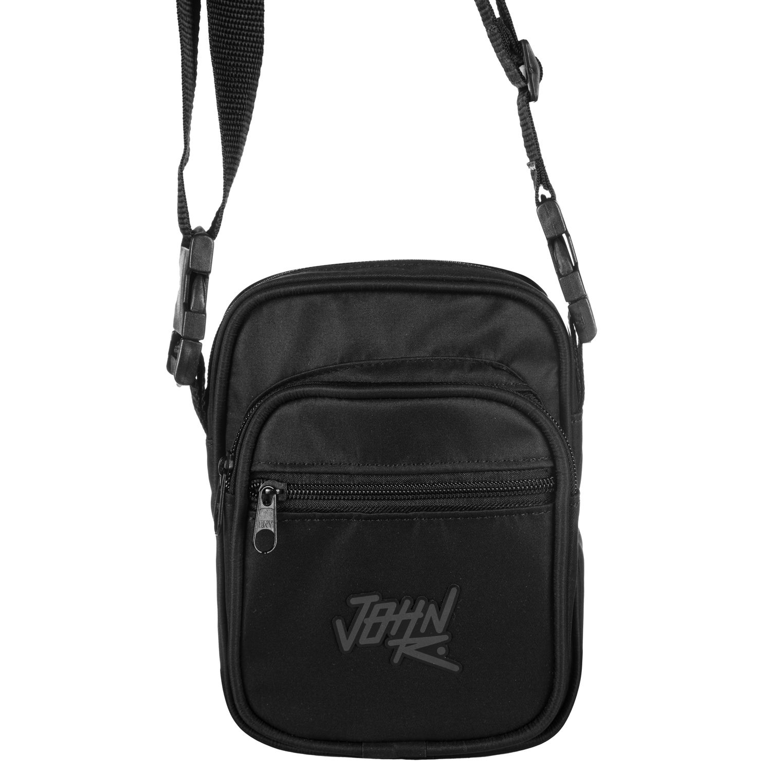 Shoulder bag de tamanho pequeno de formato levemente quadrado em lona na cor preto. Possui 3 compartimento externos, todos com fechamento em zíper, logomarca da &#39;John Roger&#39; refletiva com efeito furta-cor centralizada na parte frontal, além de alça de ombro ajustável.