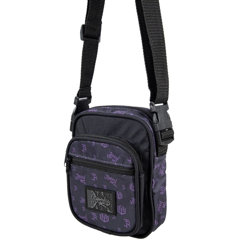 Shoulder bag de tamanho pequeno de formato levemente quadrado na cor preto com estampas em silk padronizadas com desenhos da logomarca &#39;John Roger&#39; na cor roxo em toda a bolsa . Possui 3 compartimento externos, todos com fechamento em zíper. Etiqueta emborrachada centralizada com a Logomarca da &#39;John Roger&#39;, além de alça de ombro ajustável.