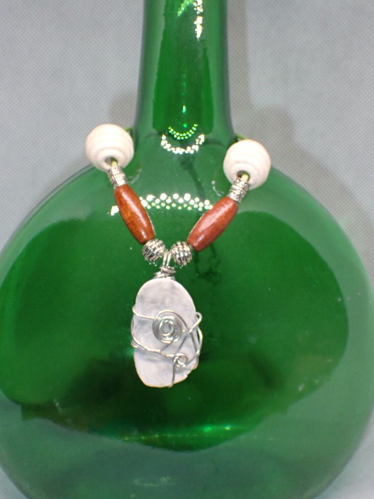 Shell Piece Wrapped in Silver Wire with Wooden Beads on a 16 inch Sea-foam Green Cord Necklace.