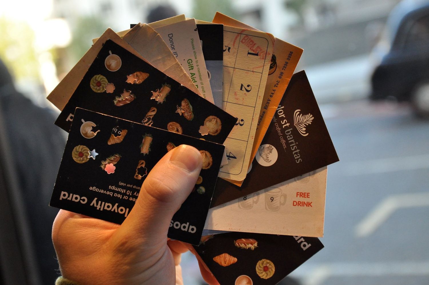 Différentes cartes fidélité tenues dans une main