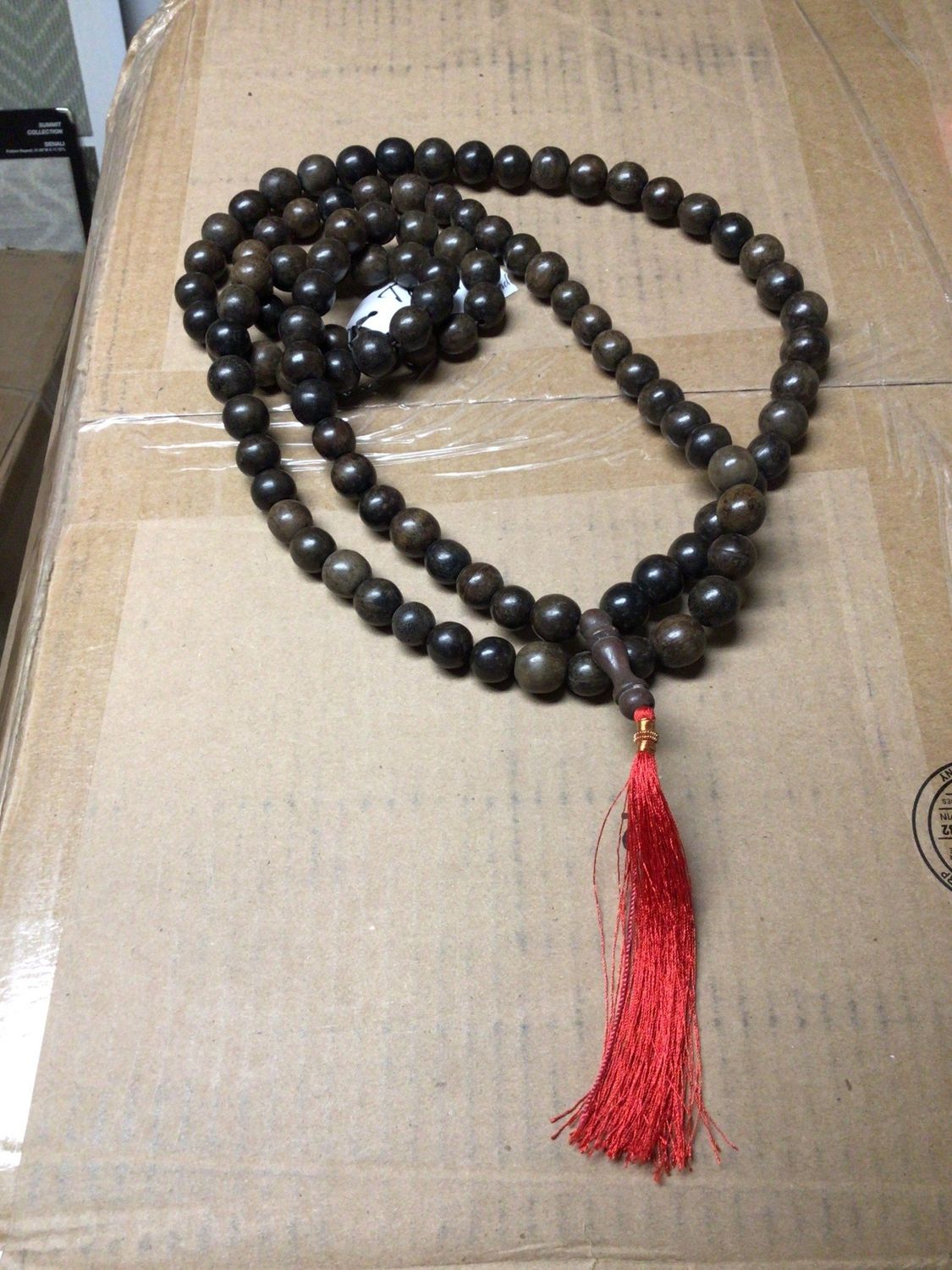 Wood bead strand with red tassel, decorative