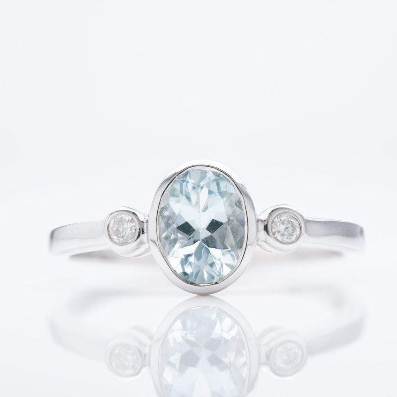 9ct White Gold Oval Cut Aquamarine & Round Brilliant Cut Diamond Rubover Set Trilogy Ring
