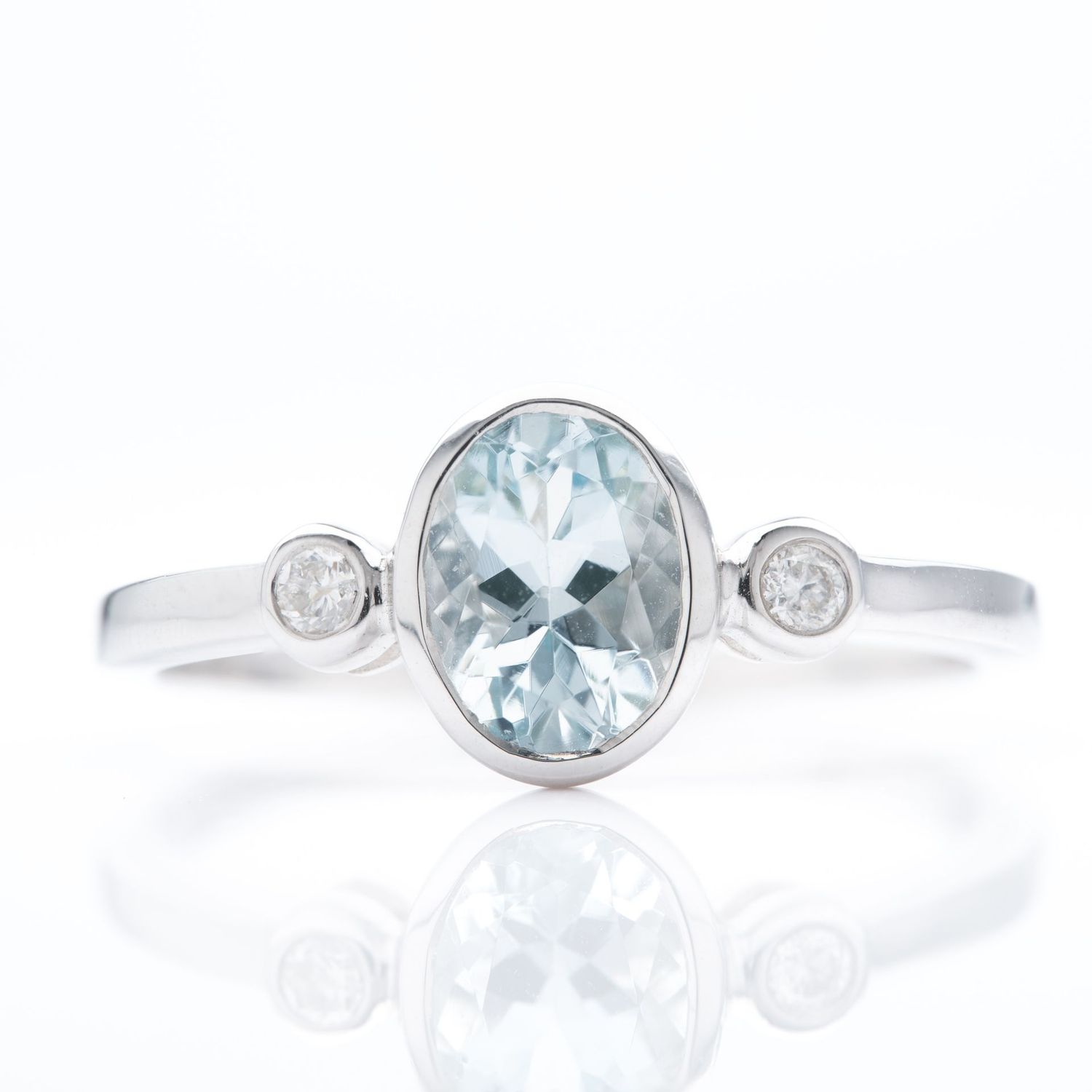 9ct White Gold Oval Cut Aquamarine & Round Brilliant Cut Diamond Rubover Set Trilogy Ring