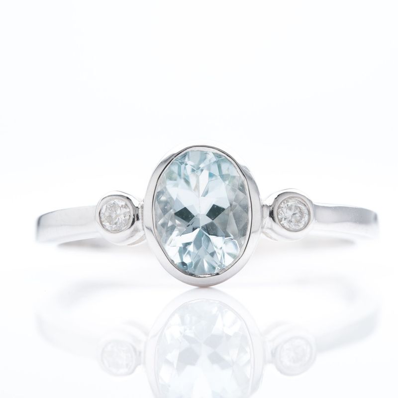 9ct White Gold Oval Cut Aquamarine & Round Brilliant Cut Diamond Rubover Set Trilogy Ring