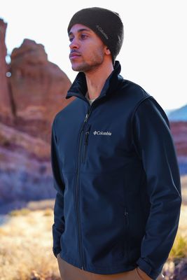 Men&#39;s softshell jacket with water-resistant fabric and breathable design features adjustable cuffs and multiple pockets.