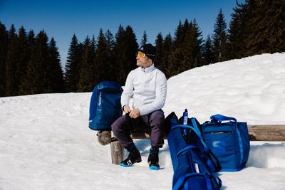 Outdoor accessory bags resting on the snowy ground, with freshly fallen snow highlighting their rugged winter designs.