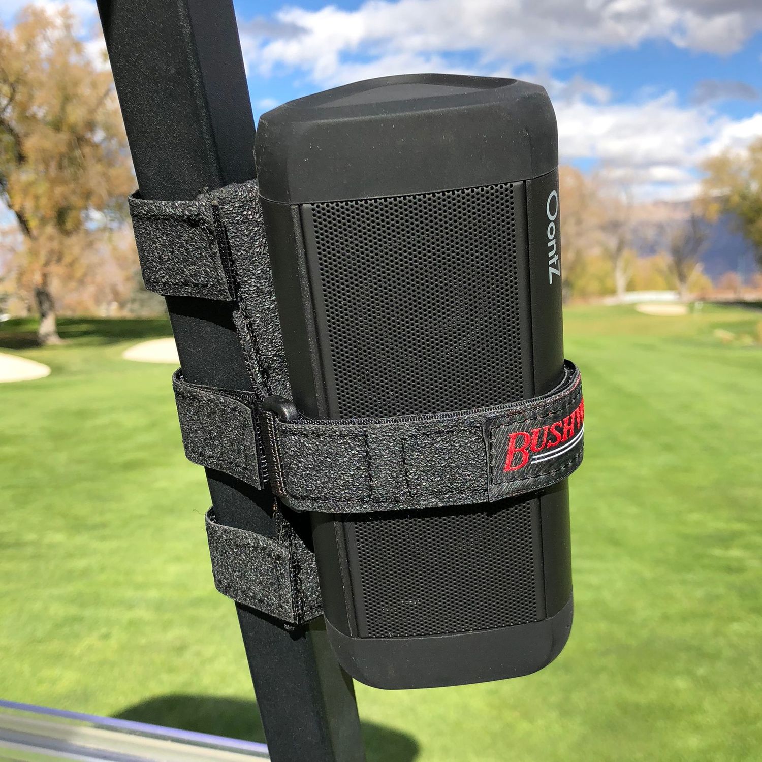 Bushwhacker speaker strap holding Bluetooth speaker securely on golf cart railing