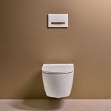 Toilettes murales Geberit Sigma50 blanches avec plaque de commande dorée brossée et rouge et finition Easy Clean.