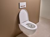 Toilettes Geberit Sigma50 blanches avec plaque de commande dorée et rouge et finition Easy Clean.