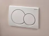 Plaque de chasse d'eau double ronde blanche Geberit Alpha01 avec tiges d'insonorisation pour réservoirs de toilettes encastrés.