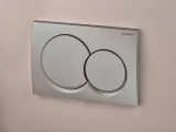 Plaque de commande double Geberit Alpha01 ronde, finition chromée mate, bouton mural.