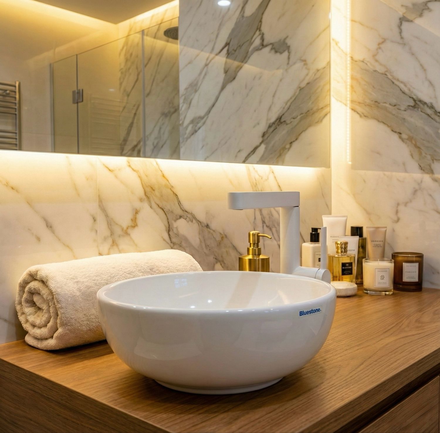 Lavabo en céramique blanche, 30 cm, sur un plan de travail en bois avec robinet doré et fond en marbre.