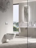 Plaque de commande carrée chromée Geberit Alpha25 fixée au mur avec toilettes et accessoires de salle de bains modernes.