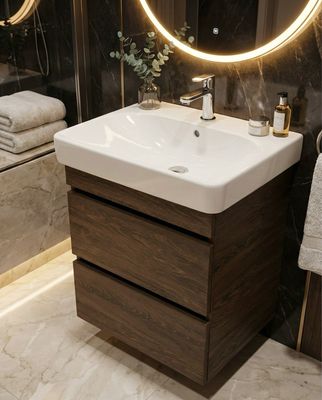 Meuble vasque de salle de bain Geberit Smyle 60cm à deux tiroirs en bois foncé avec vasque en céramique blanche installée.