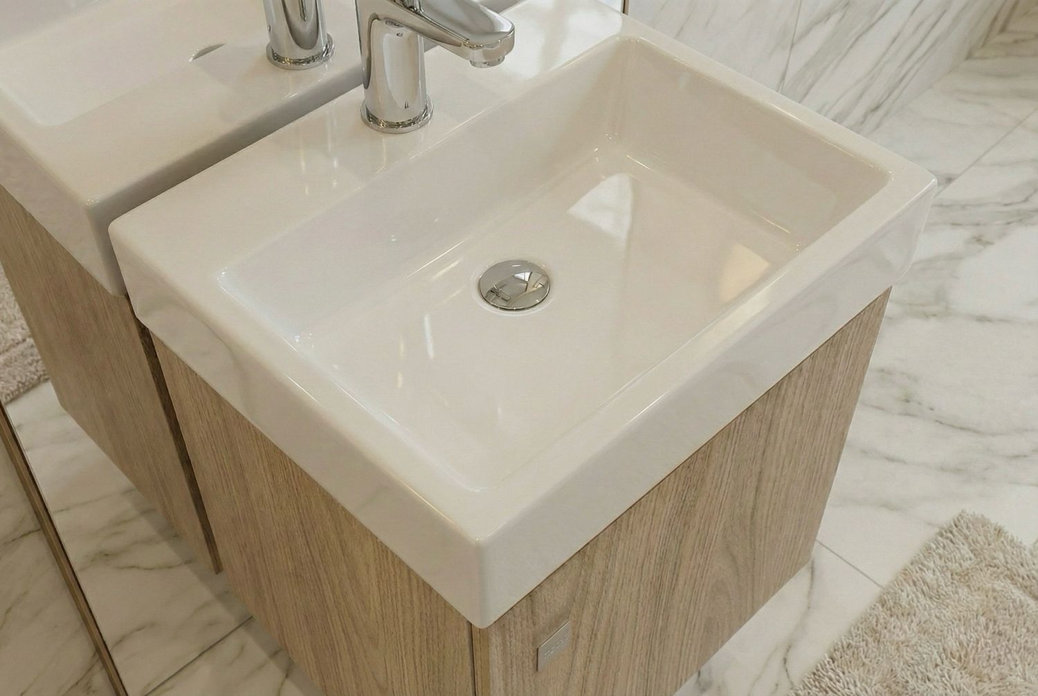Lave-mains Aden 35 cm, lavabo rectangulaire blanc avec robinet argenté et meuble sous-vasque en bois installé.