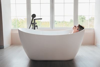Baignoire îlot ovale en acrylique blanc Deante Arnika PureOne 170x72 cm avec robinetterie moderne.
