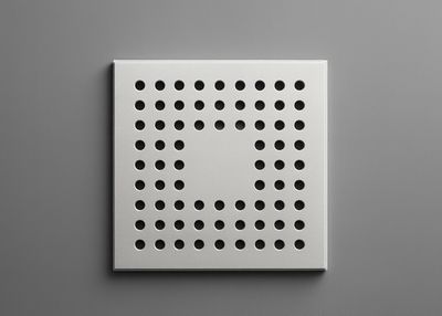 Grille d'évacuation de douche carrée en acier inoxydable chromé avec de nombreux petits trous de drainage.