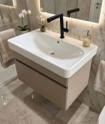 Meuble vasque de salle de bain Geberit Smyle 75cm à un tiroir, avec lavabo blanc et robinet noir.