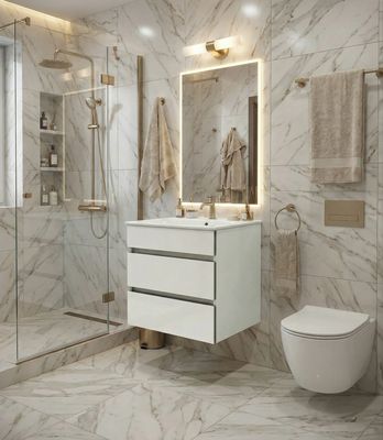 Meuble-lavabo blanc avec deux tiroirs, robinetterie dorée et carrelage en marbre autour des toilettes et de la douche.