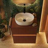 Lavabo elliptique en céramique blanche 45 x 35 cm sur meuble-lavabo en bois marron avec robinet noir.