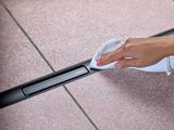 Caniveau Geberit CleanLine30, noir mat, 30-110 cm, acier inoxydable, en cours de nettoyage avec un chiffon.