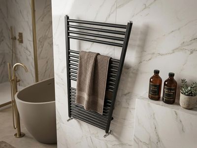 Sèche-serviettes Fondital Cool 1160/500 noir avec deux serviettes et accessoires de salle de bain à proximité.