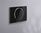 Plaque de commande Geberit Sigma10 noire avec anneau chromé brillant et design élégant fixé au mur.