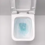 Cuvette de toilette Geberit iCon Square sans rebord, avec fixations invisibles et eau bleue à l'intérieur, en céramique blanche.