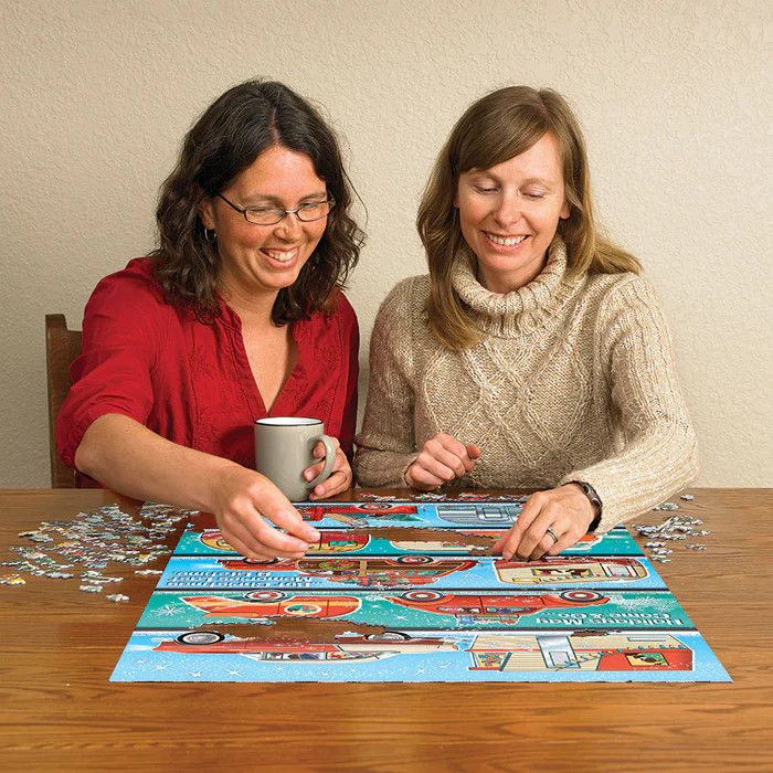 Two women happily putting together a 1,000 piece holiday puzzle.