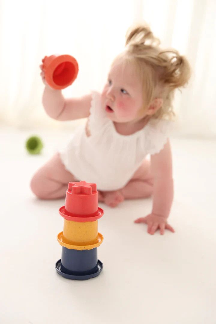 A small child playing with tolo rainbow stackers.