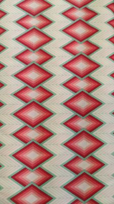 Fondo beige con agua marina y rombos de rojos a coral.