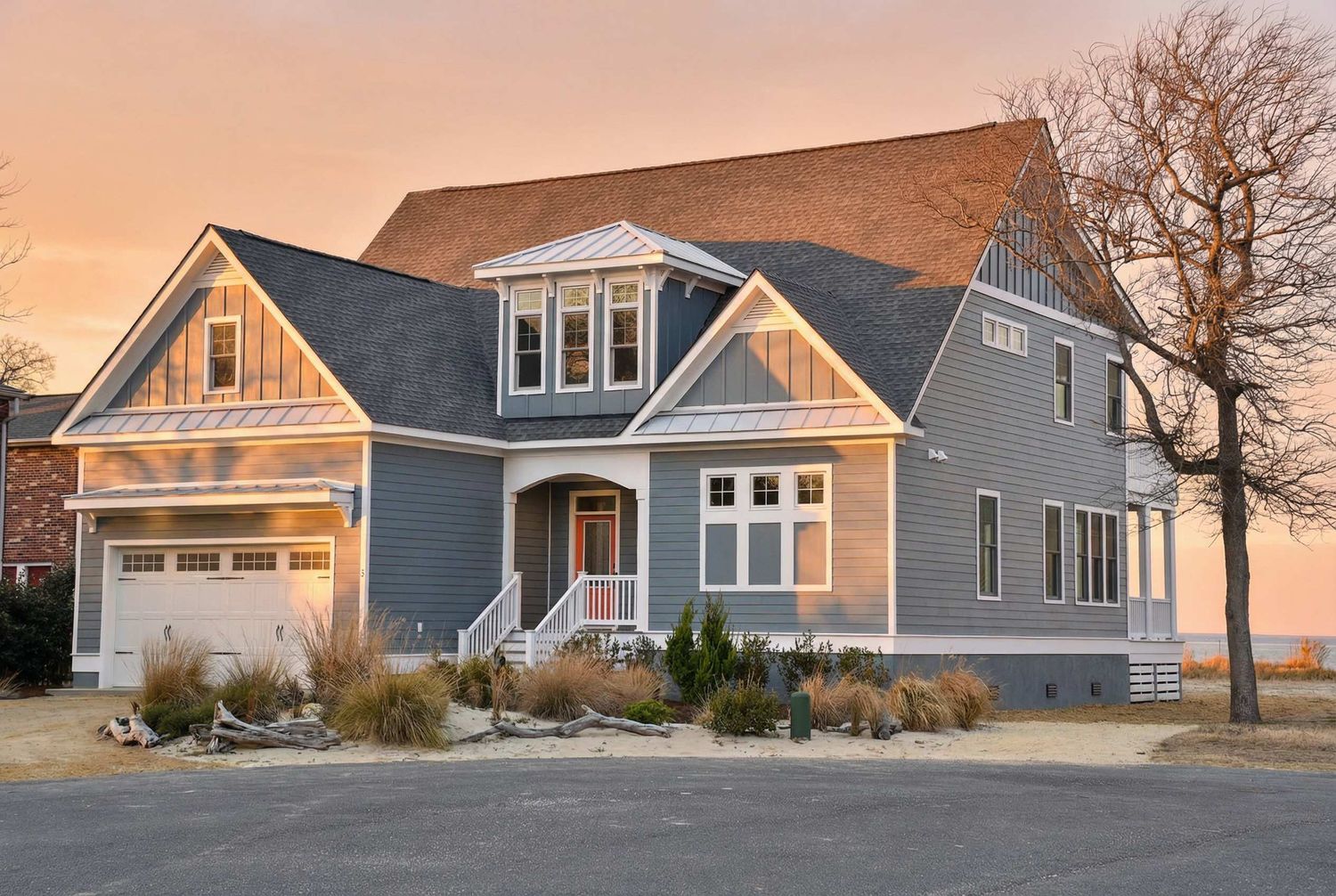 Exterior rendering of a coastal-style residential home plan with gray siding, metal roof details, and a covered front entry.