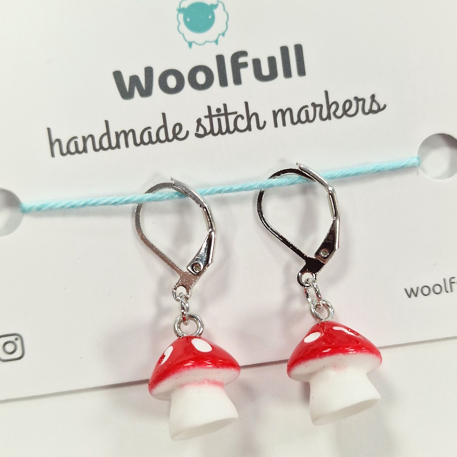 2 red and white mushroom stitch markers.