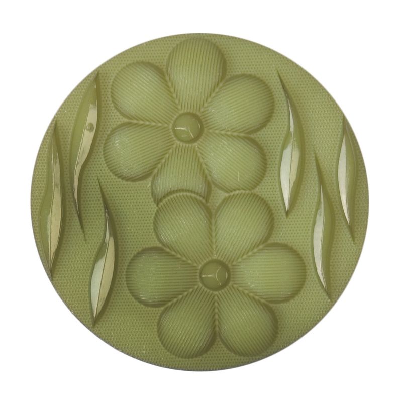 A round green button with a raised flower and leaf design.
