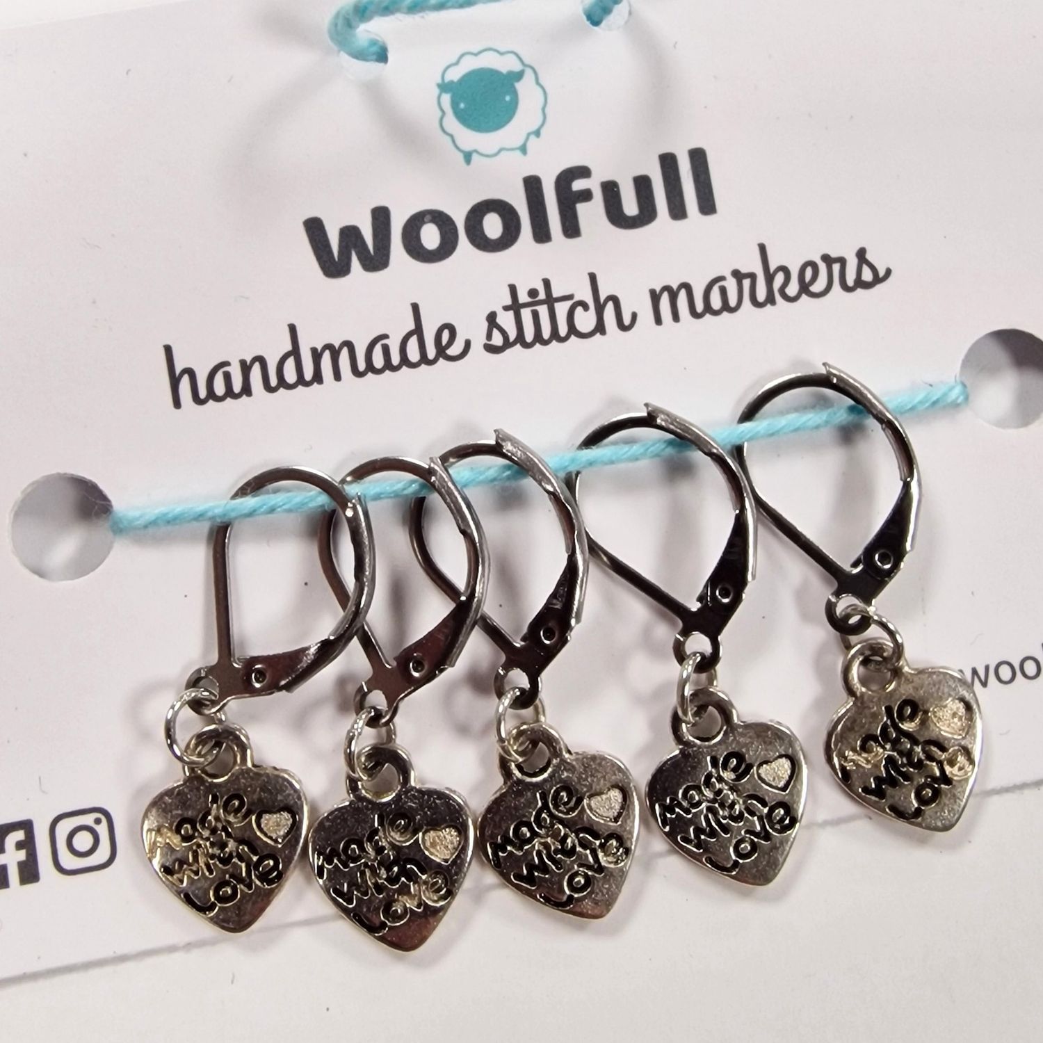 5 heart shaped stitch markers with &#39;Made with Love&#39; written on them.