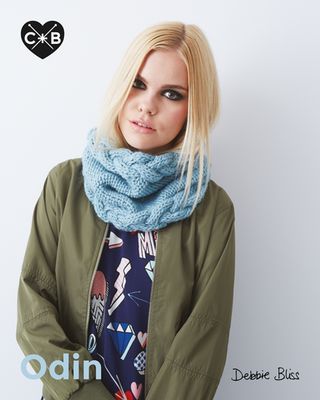 A woman is wearing a chunky pale blue knitted cowl.