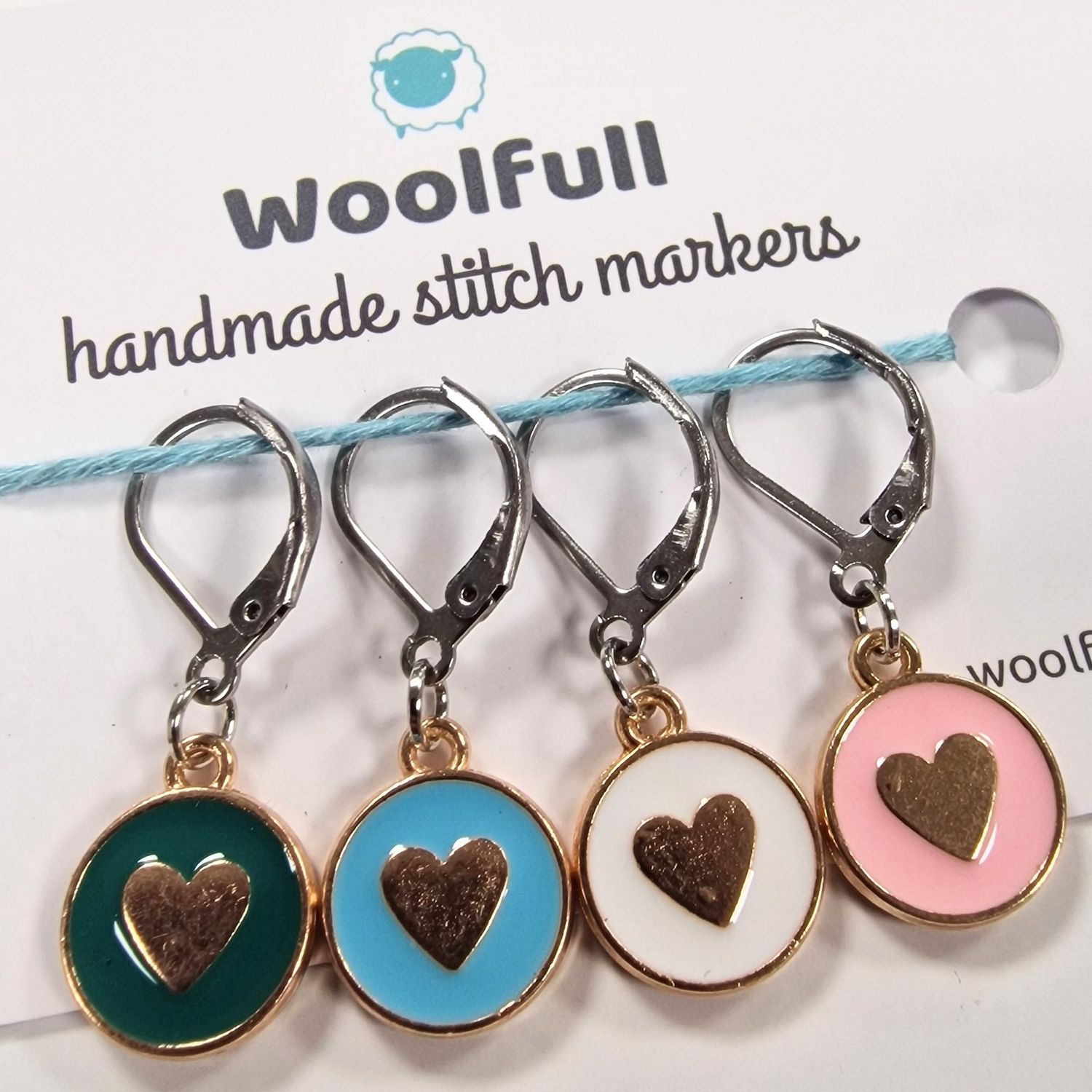 4 coloured circular stitch markers with hearts on them.
