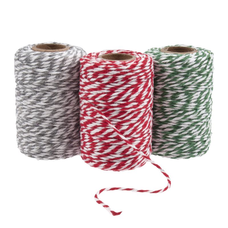 Three spools of festive coloured twine. One silver, one red and one green.
