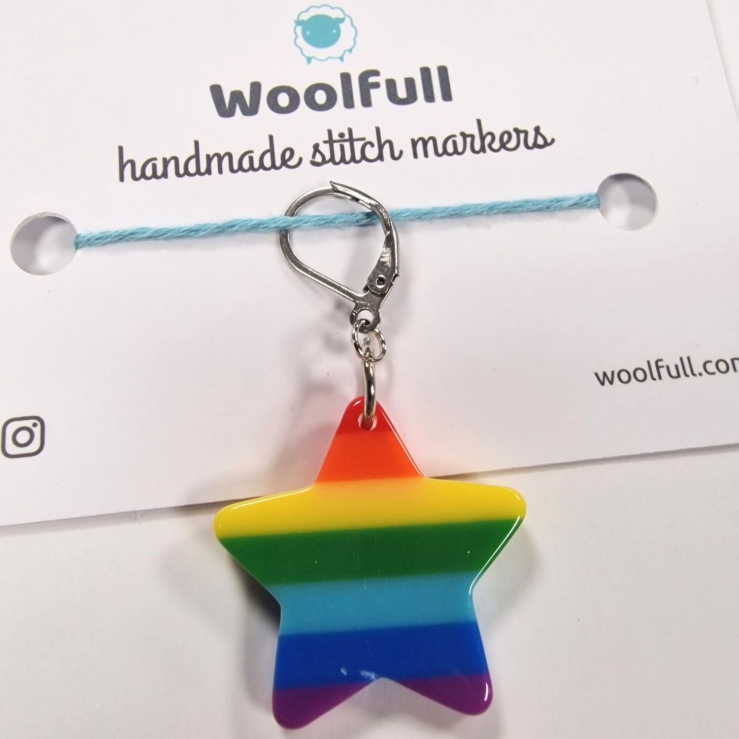 A plastic rainbow star shaped stitch marker.