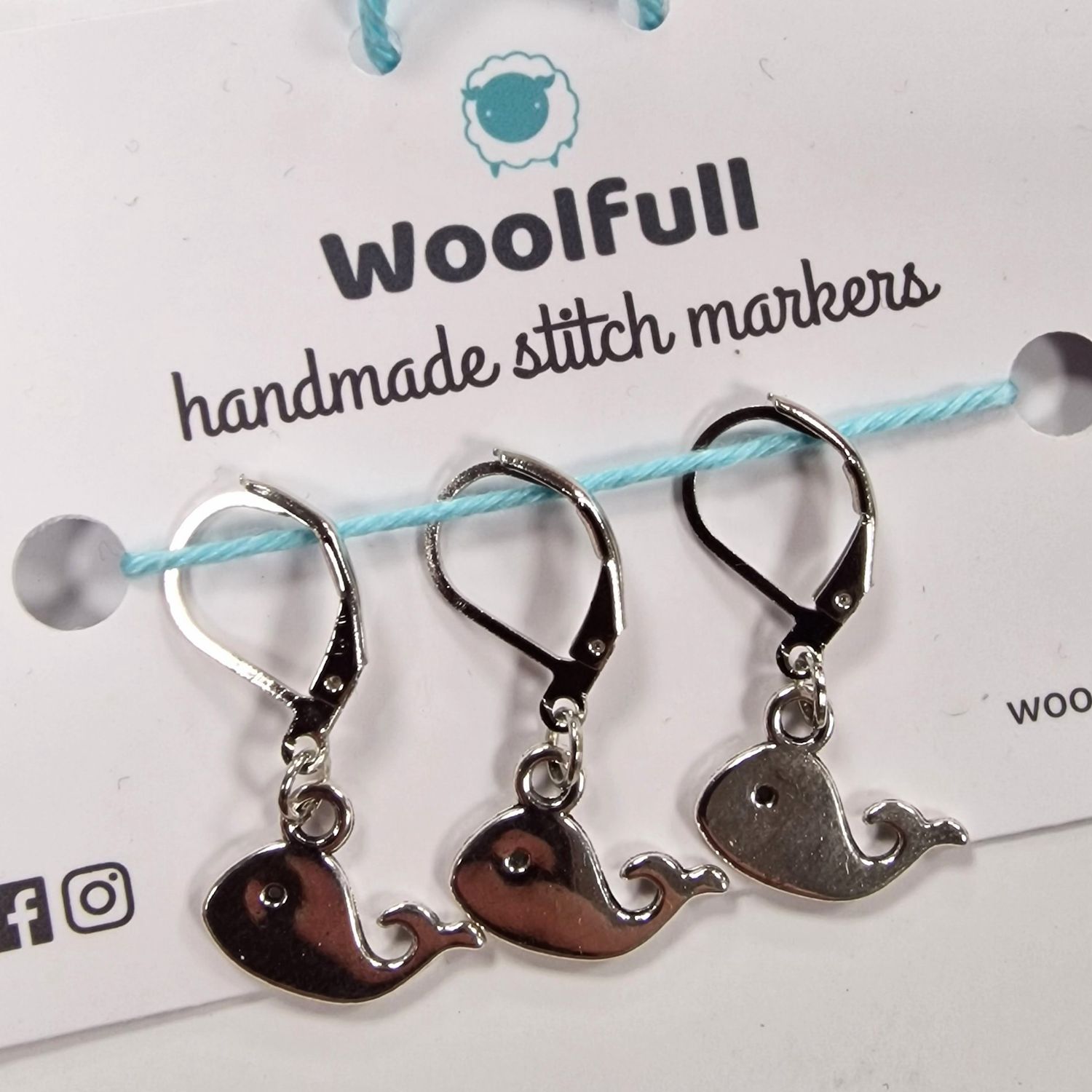 3 silver whale shaped stitch markers.
